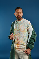 Stylish African American man striking a pose against a vivid blue background.