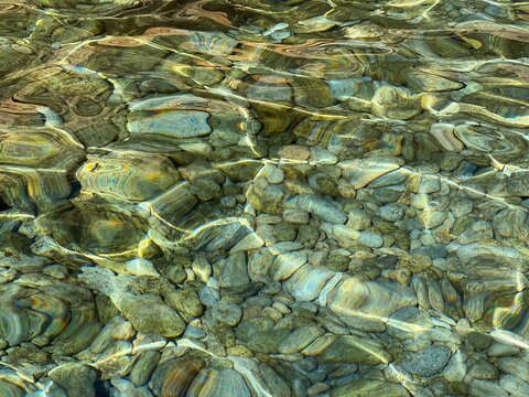 Transparent sea water with stones and peblles at the seabed