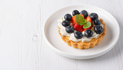 Creamy cheesecake cake with blueberry and strawberries. Copy Space