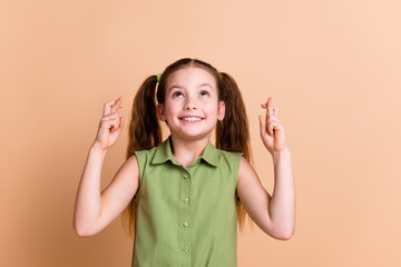 Photo of positive child look up cross fingers dream please isolated pastel color background