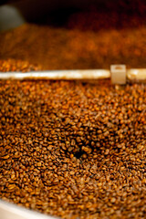 close-up of a coffee roasting factory inside drum roasting stirring coffee