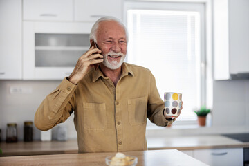 Coffee, phone and elderly man in kitchen talking on the phone in his home. Happy, communication and...