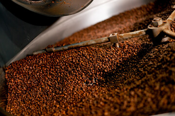 close-up of a coffee roasting factory inside drum roasting stirring coffee