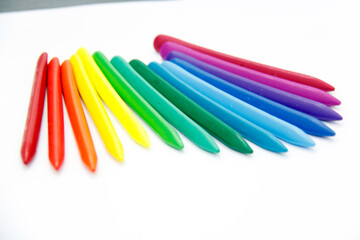 Triangular colored crayons on a white background