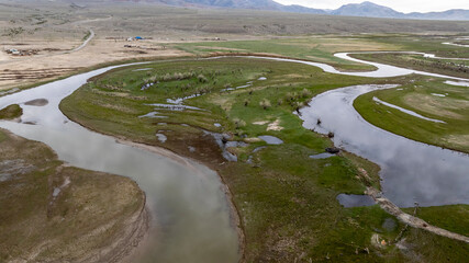 landscape of mountains, lakes and an unusual bend of rivers from the height of a drone flight in the southern regions of Altai in May