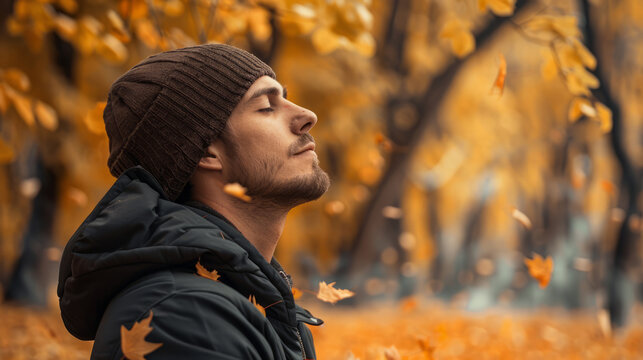 Peaceful man relaxing and breathing deeply in autumn park