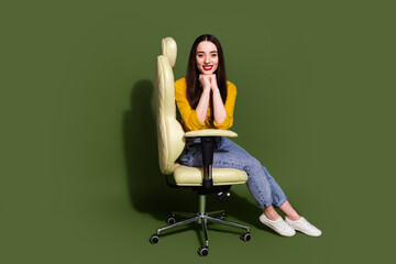 Full length photo of adorable lovely girl wear yellow shirt sitting leather armchair empty space isolated green color background