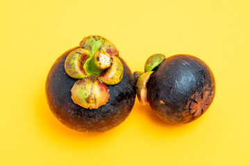Garcinia mangostana. Fresh spiced mangosteen fruit on a yellow background