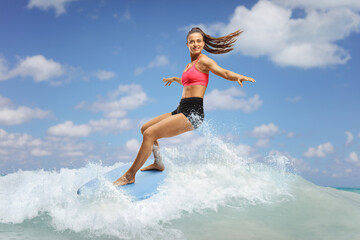 Female surfer riding a surfboard on a wave