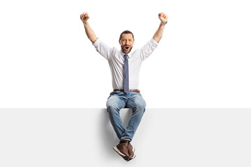 Professional man sitting on a blank panel and raising arms