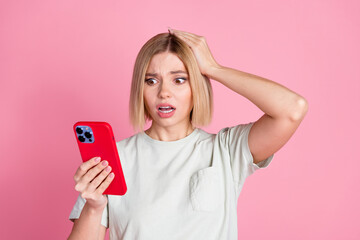 Portrait of astonished scared girl with bob hair wear white t-shirt staring at smartphone arm on...