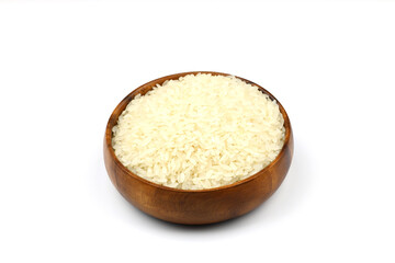 Raw white rice on wooden background. Long uncooked rice in wooden plate. Natural organic food. Traditional Asian cereal culture.