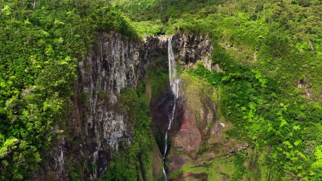 Picturesque flying over the mountain creek fall down from steep high cliff to wide green jungle valley. Cascade 500 Pieds waterfall also known as Cascade des Galets on Mauricius island in Indian ocean