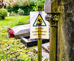 Warntafel vor sehr glatten Wegen auf dem Highgate Cemetery Ostteil Camden, London	
