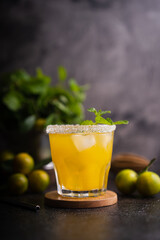 Fresh summer orange mojito with tangerine orange, mint and ice on black background