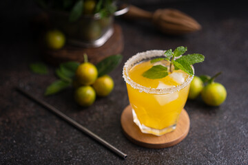 Fresh summer orange mojito with tangerine orange, mint and ice on black background