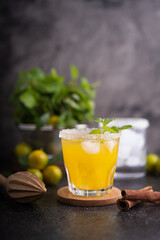 Fototapeta premium Fresh summer orange mojito with tangerine orange, mint and ice on black background