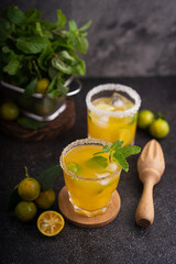 Fresh summer orange mojito with tangerine orange, mint and ice on black background