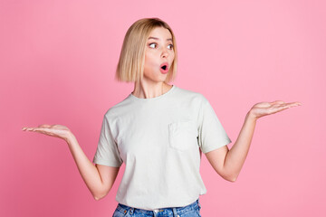 Portrait of impressed girl with bob hair wear white t-shirt arms comparing products look empty...