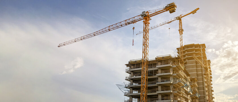 Tower cranes  at  construction site - Powered by Adobe