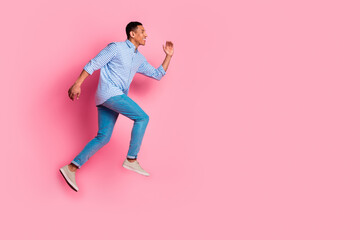 Full length photo of handsome carefree guy wear plaid shirt running jumping high emtpy space...