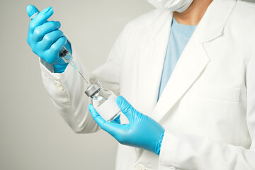 Fototapeta premium doctor or scientist holding a syringe with ampules vaccine, bottle for injection