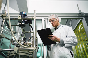 A man in a white lab coat is looking at a clipboard