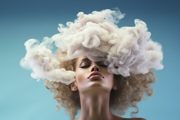 Fototapeta premium Artistic image of a woman with smoky cloud-like hair on a blue background