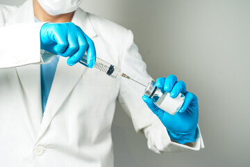 doctor or scientist holding a syringe with ampules vaccine, bottle for injection