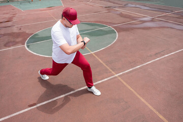 Athletic bearded man warms up before workout at the stadium