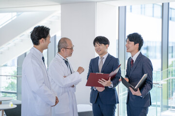 病院で笑顔で会話する男性医師と医薬情報担当者MR