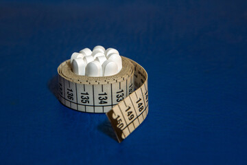 Tape measure with weight loss medications, dietary supplements and appetite suppressants to combat obesity.