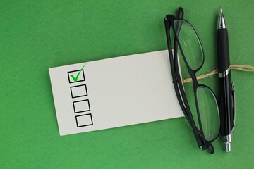 glasses, pen and paper with correct marks. blank checklist. inspection concept