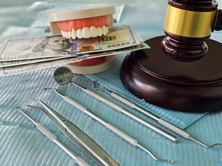 Dental insurance white tooth and judge gavel. Mistakes of dentists responsibility and punishment