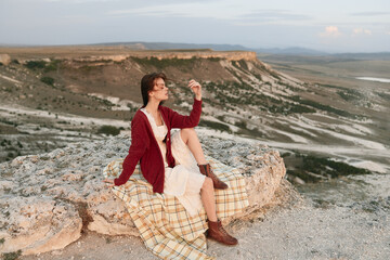 Solitude and serenity woman sitting on rock in the desert holding a glass of wine, travel adventure...