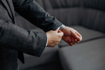 A man in a suit is getting ready to tie his tie. Concept of formality and professionalism, as the...