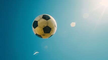 Naklejka premium Soaring to Victory: Dynamic Soccer Ball in 4K Wallpaper，A football being kicked into the sky, blue sky, shot from below, football match live broadcast, European Cup 2024, 4k high-definition wallpape