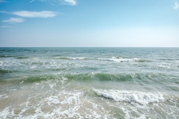Tranquil Beach Scene with Blue Sky and Gentle Waves Rolling in Towards Shore