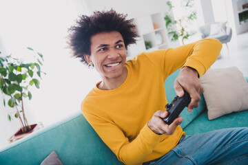 Photo of crazy cheerful glad man sitting divan playing video game weekend vacation rest relax...