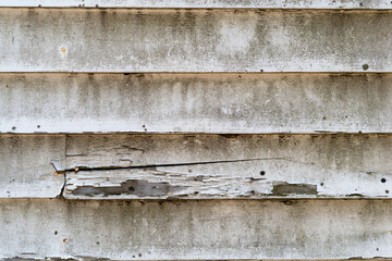 Very old wood clapboard siding with mold chips and cracks.