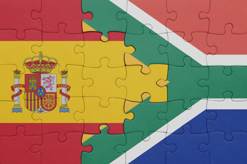 puzzle with the colourful national flag of south africa and flag of spain.