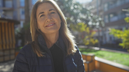 Mature caucasian woman smiling outdoors in daylight wearing a jacket
