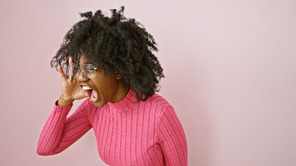 African american woman shouting indoors with a clear wall background, exhibiting emotions and...