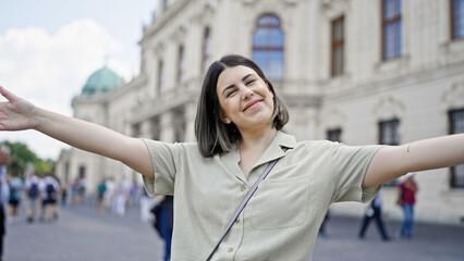 Young beautiful hispanic woman with open arms at Belvedere Palace in Vienna