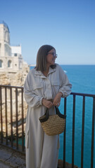A young, beautiful hispanic woman enjoys a sunny day at a picturesque viewpoint overlooking the...