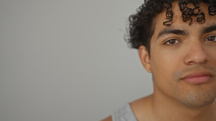 Obraz premium Portrait of a pensive young hispanic man looking away, isolated over a white background