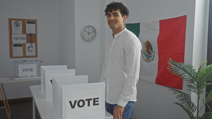 Handsome young hispanic man in white shirt standing confidently in a mexican polling station with a...