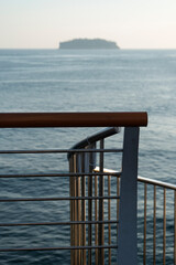 View of the bridge fence against the island on the sea