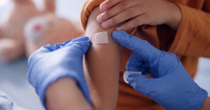 Child, arm and pediatrician hand with plaster for immunization shot or testing, healthcare or health. Kid, clinic and helping consultation for medical treatment or youth job, diagnosis or insurance