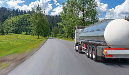Fuel truck on a picturesque road. A silver tank truck transports fuel.